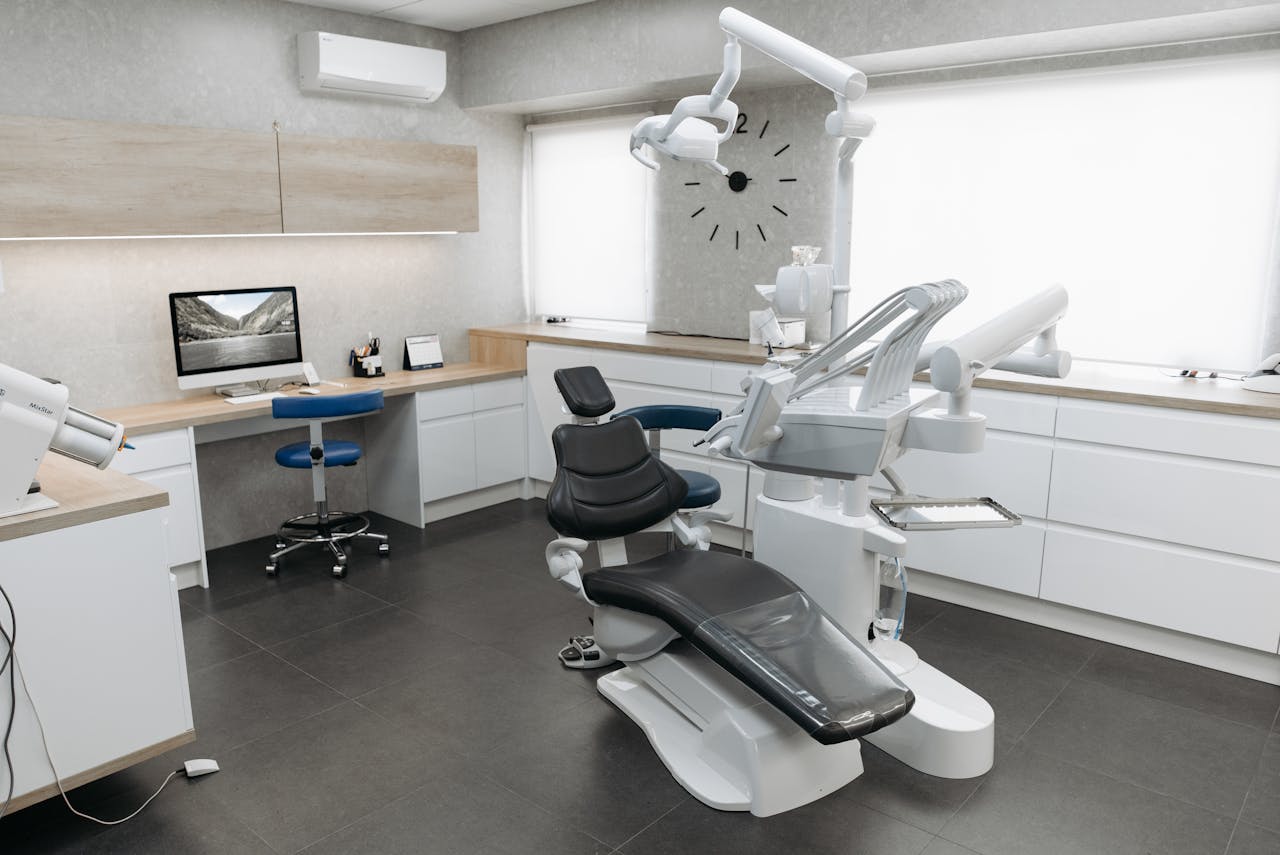 who-we-are A modern dental clinic interior featuring a dental chair and equipment with a minimalist design.